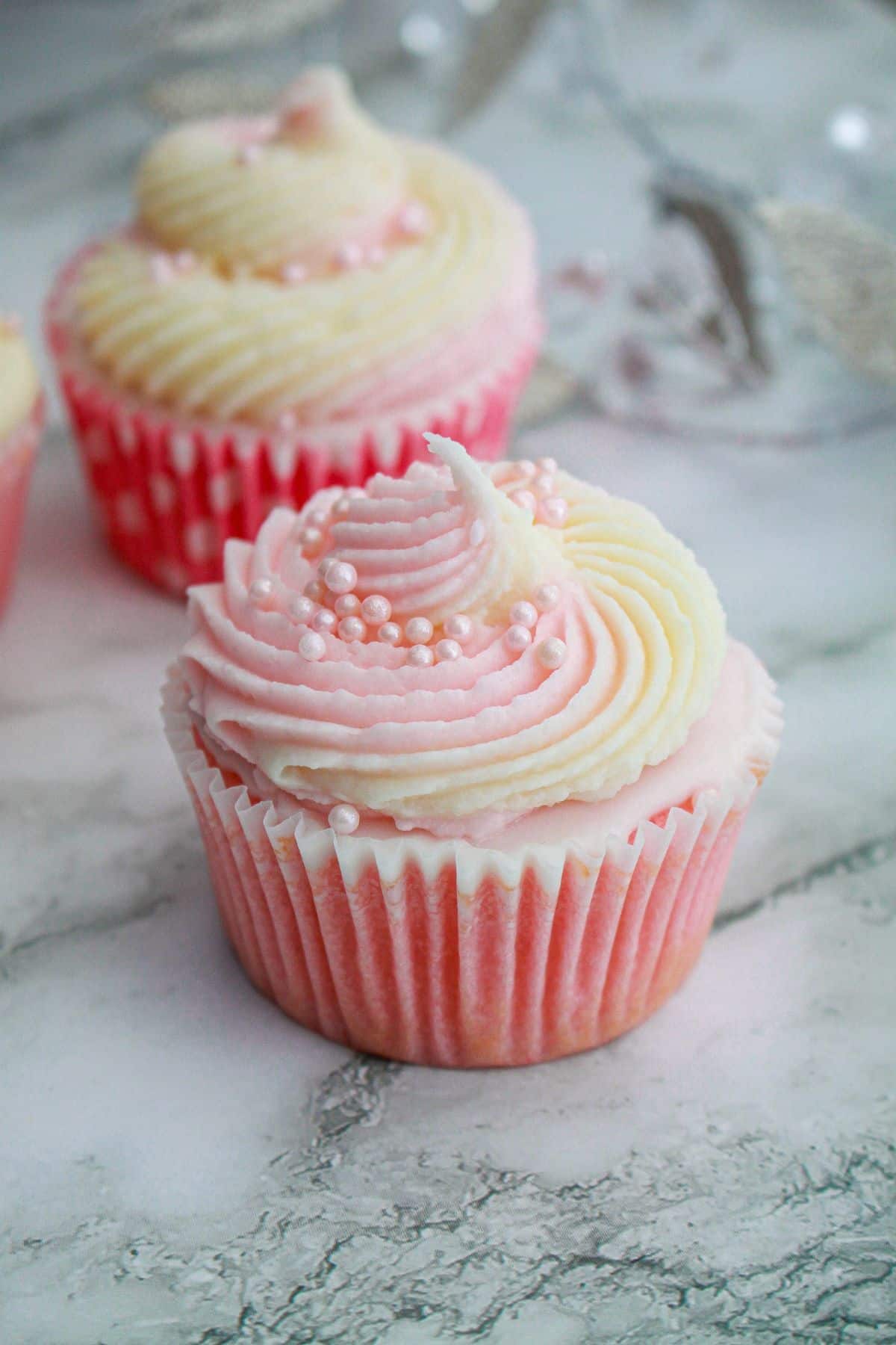 pink champagne cupcake on a marble counter.