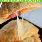 puff pastry pizza pockets on a plate with one held in a woman's hand.