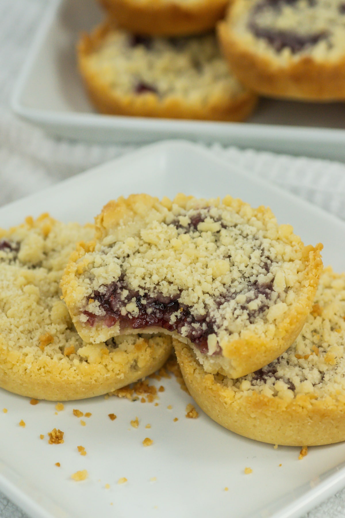 three raspberry crumble cookies on a plate.
