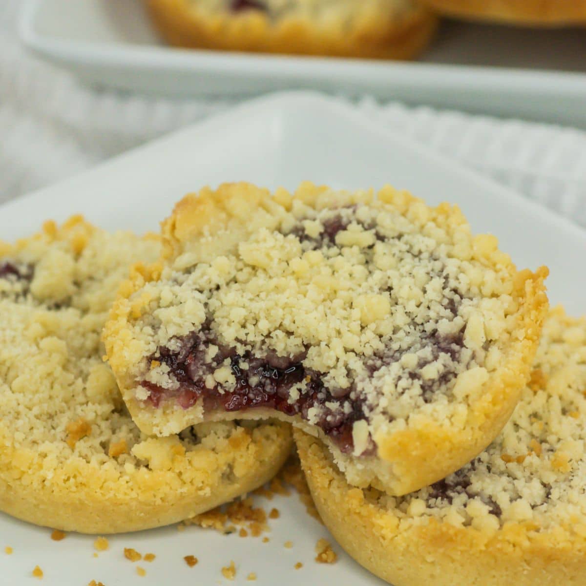 three raspberry crumble cookies on a plate.