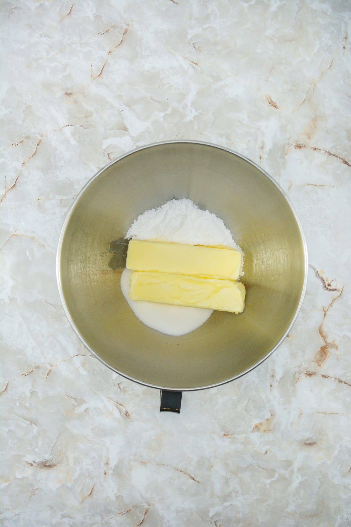 butter and sugar being creamed together in a large mixing bowl.