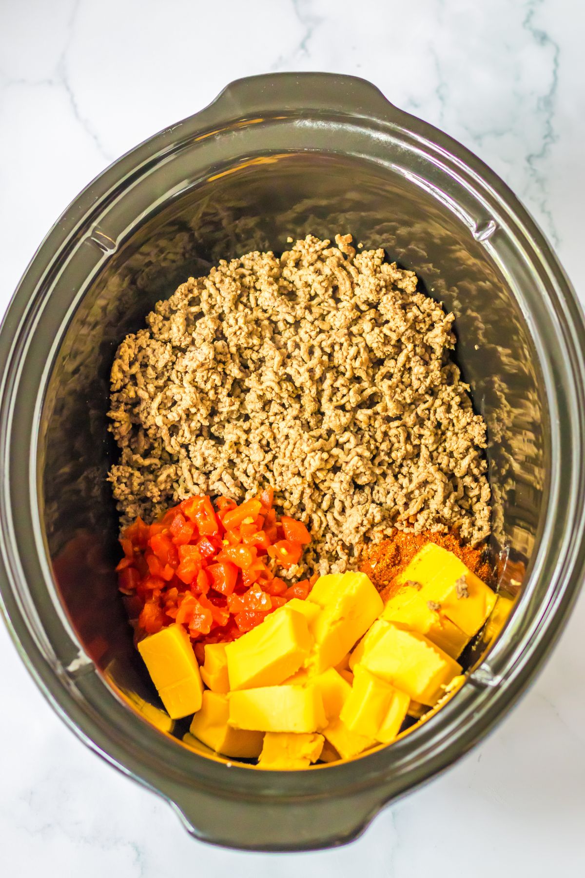 ground beef, rotel, velveeta and taco seasoning in a slow cooker.