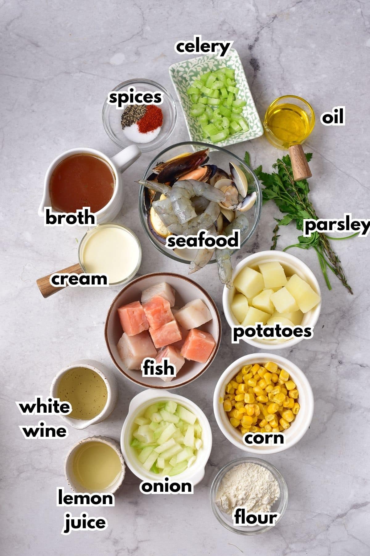 bowls of ingredients to make seafood chowder on a backdrop.