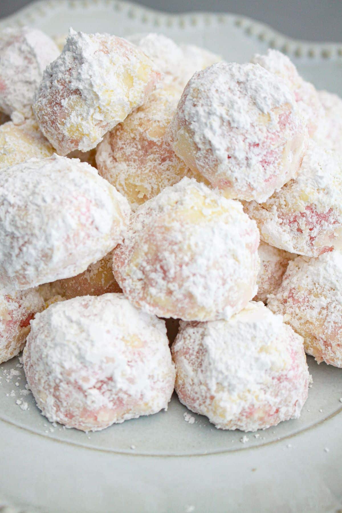 stack of strawberry snowball cookies on a plate.