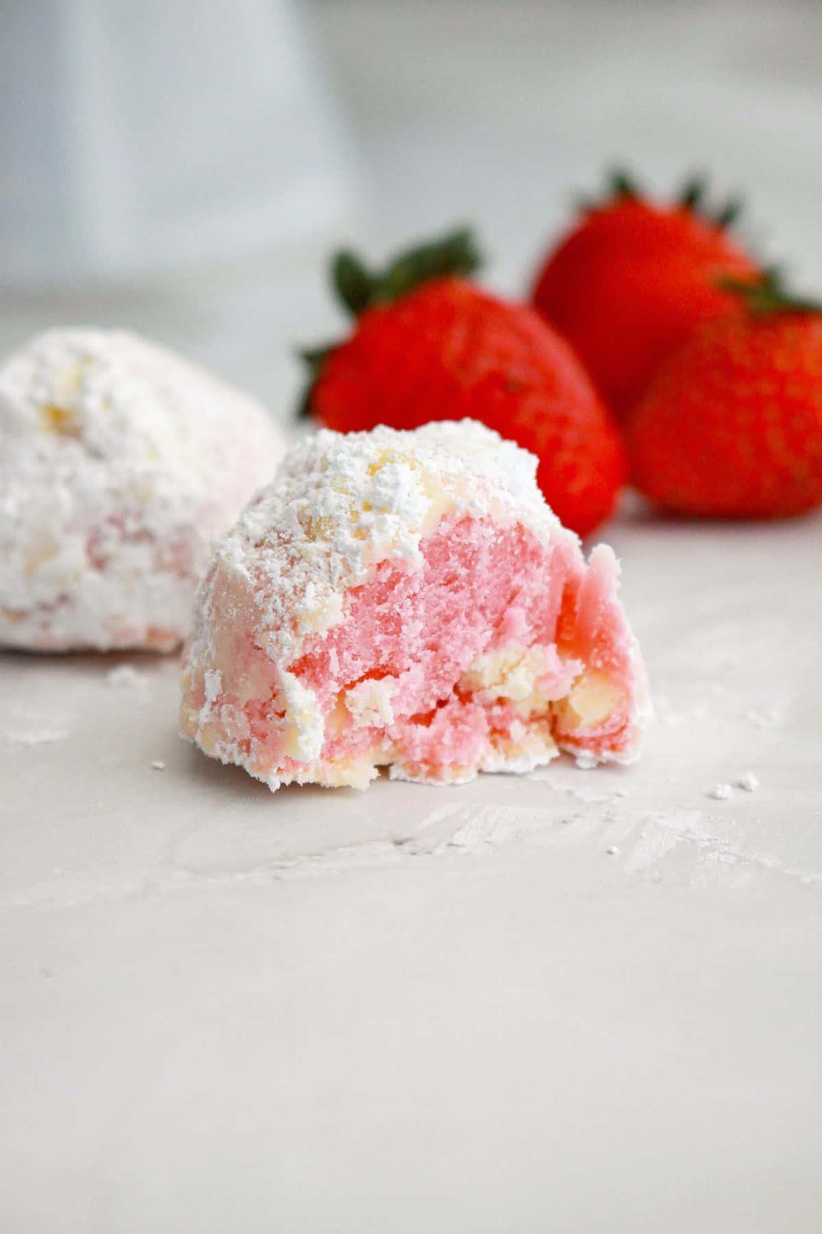 single snowball cookie on a marble counter.