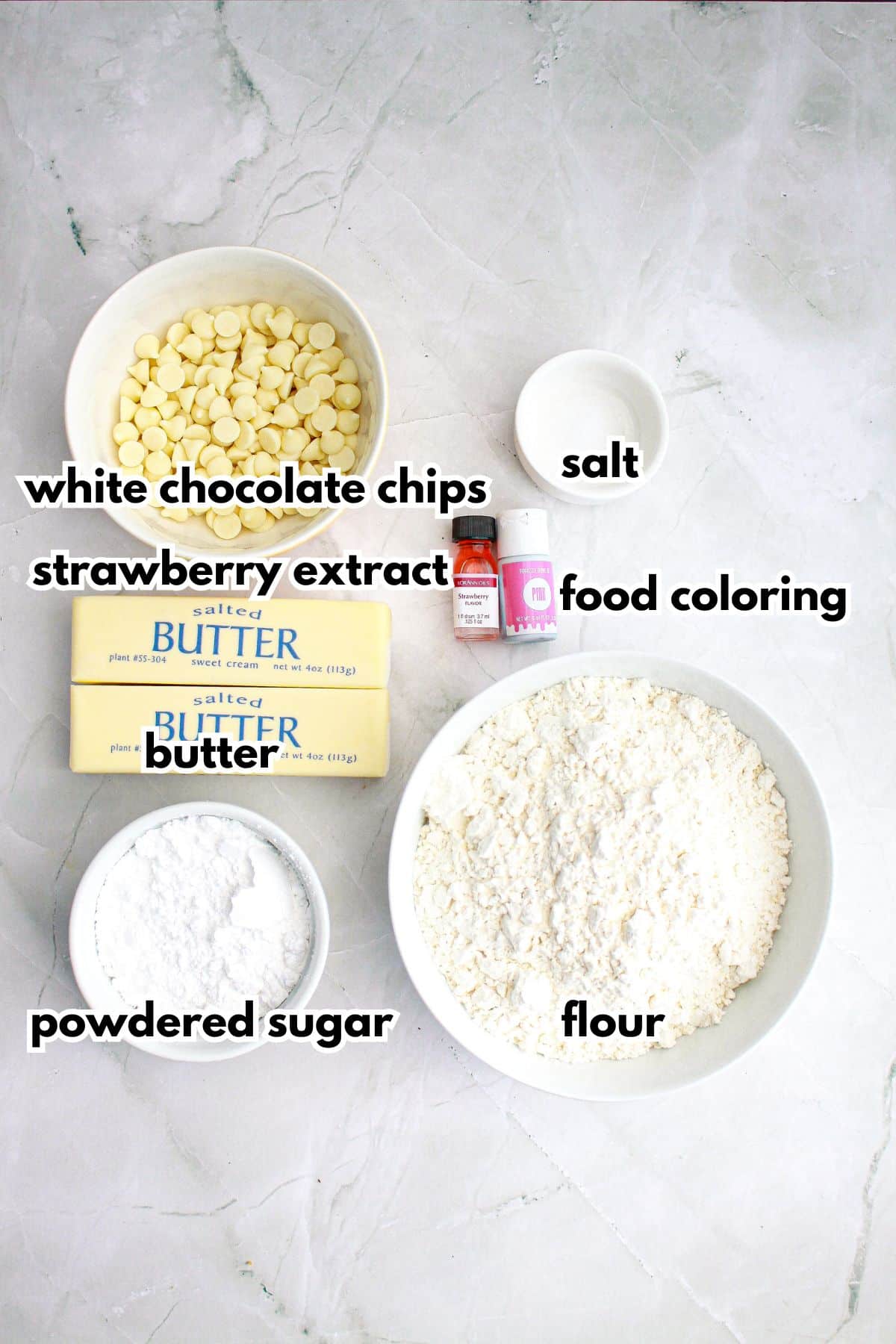 bowls of white chocolate chips, strawberry extract, butter, salt, food coloring, powdered sugar, and flour.