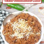 bowl full of texas roadhouse chili topped with a sprinkle of grated cheese.