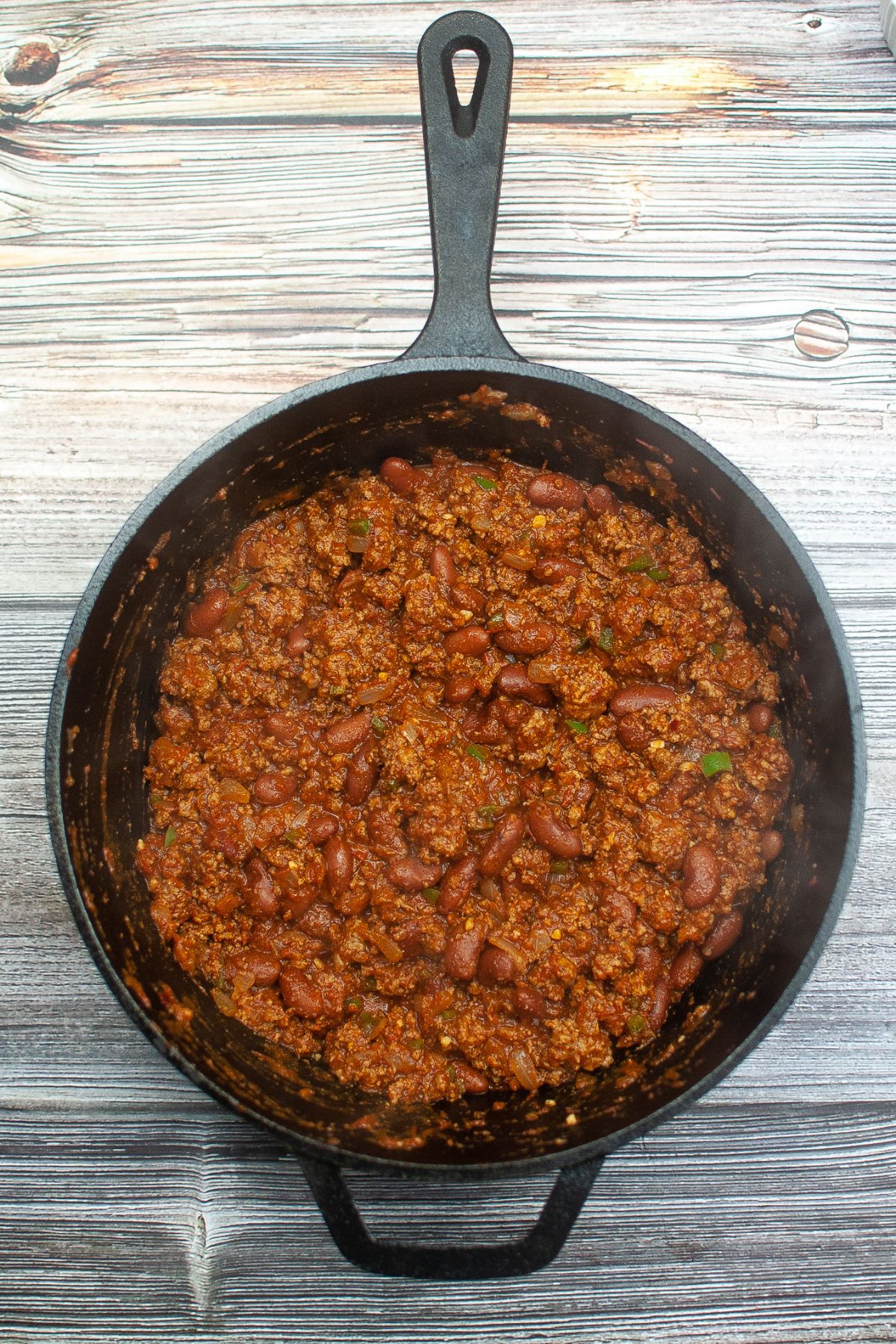 finished and thickened chili in a cast iron skillet ready to serve.