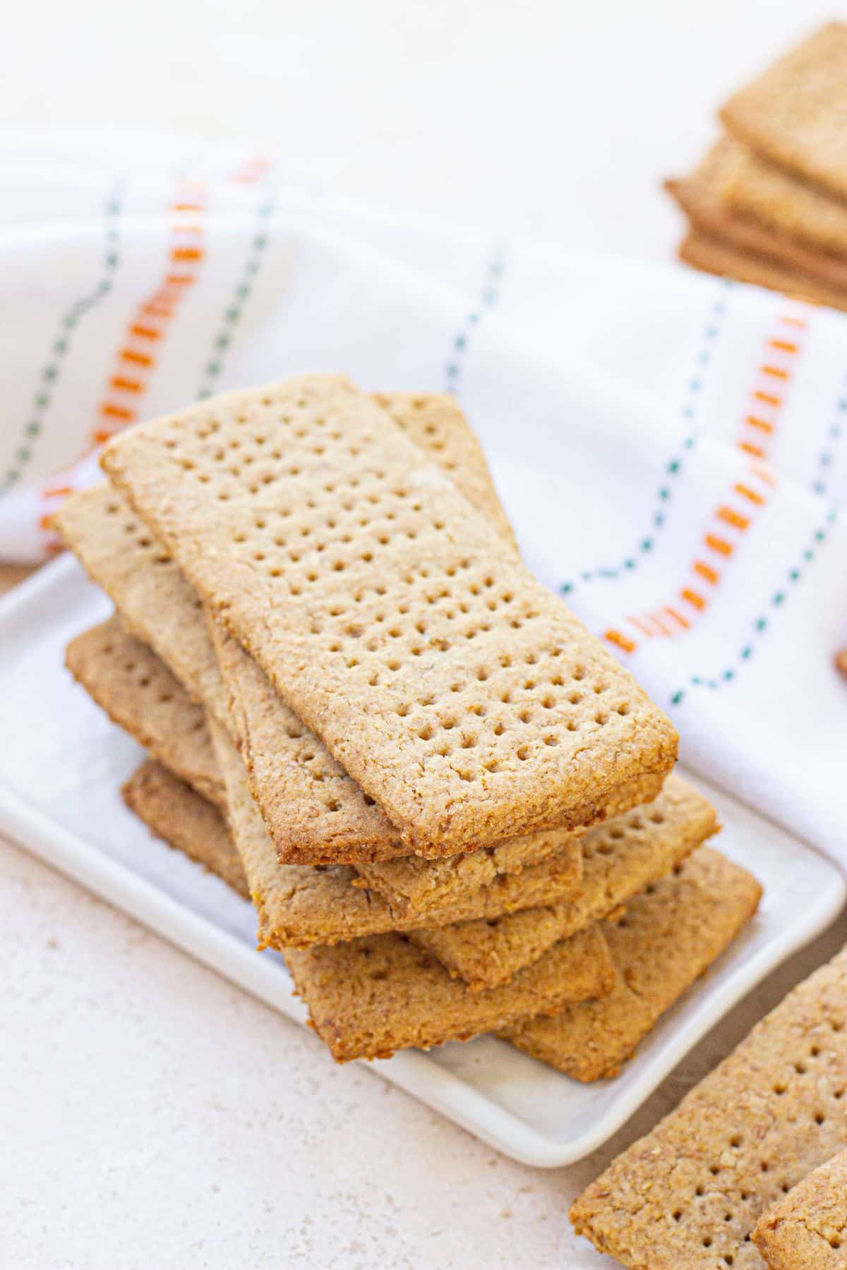 whole wheat graham crackers stacked on a small plate.