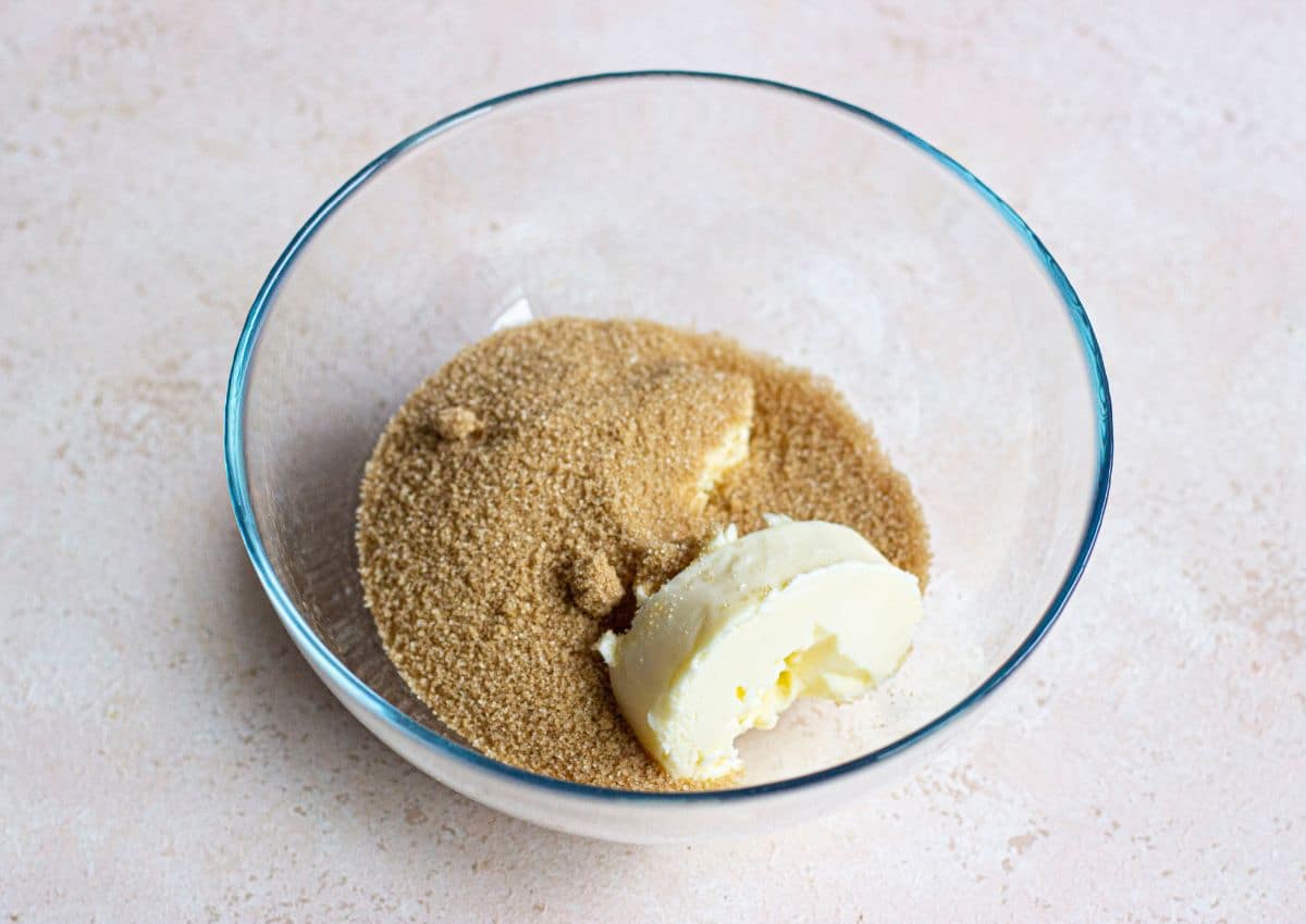 butter and brown sugar being creamed in a glass bowl.