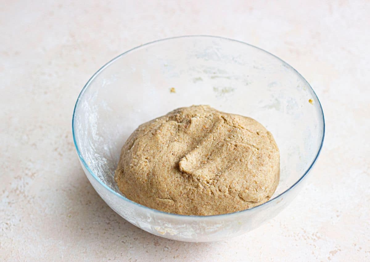 raw dough being finished in a glass mixing bowl.