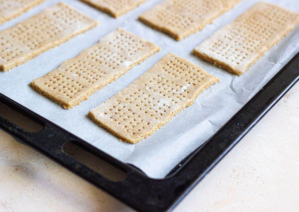 raw cracker dough on a parchment lined baking sheet.
