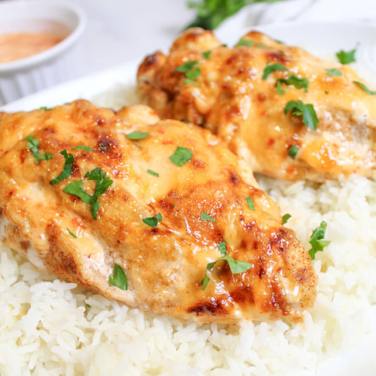 air fryer bang bang chicken on top of a bed of white rice on a plate.