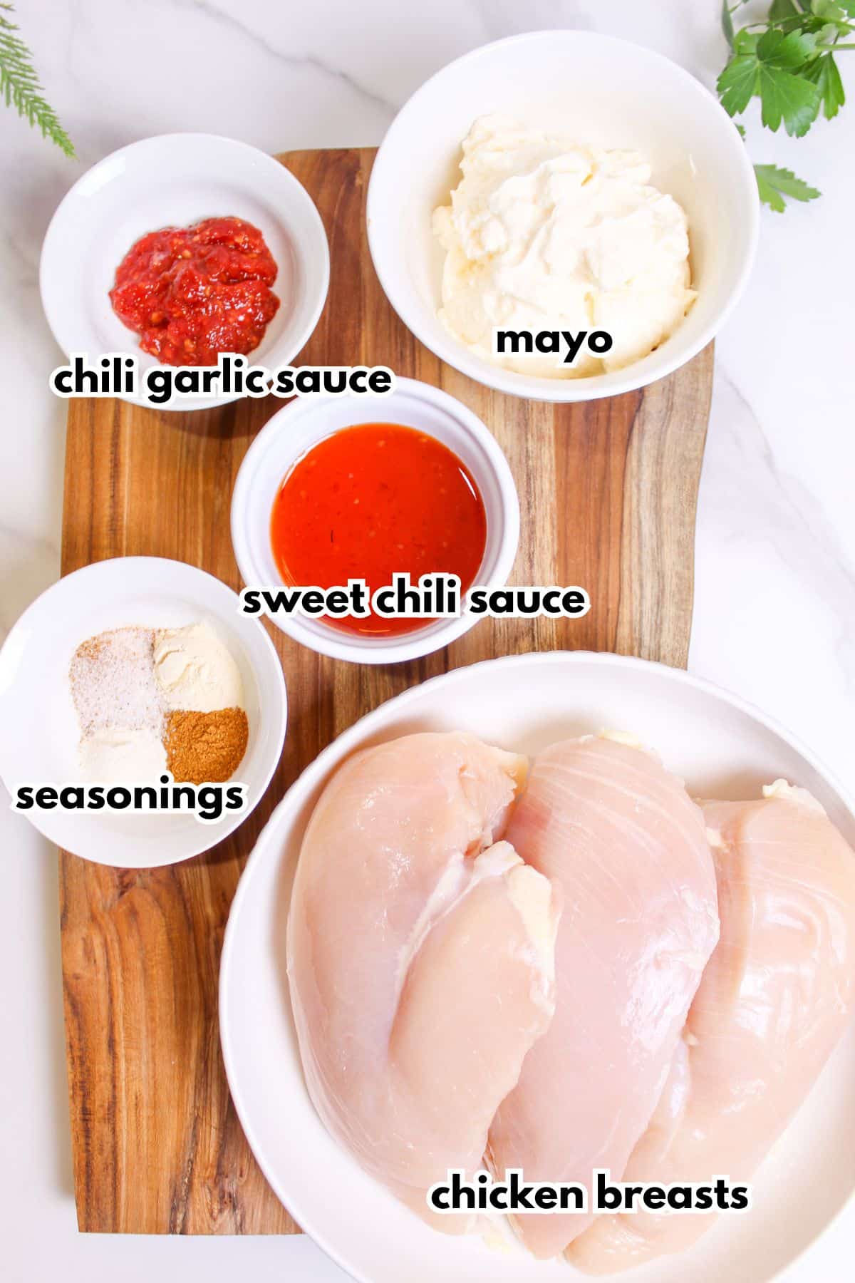 bowls of chili garlic sauce, mayo, sweet chili sauce, seasonings, chicken breasts.