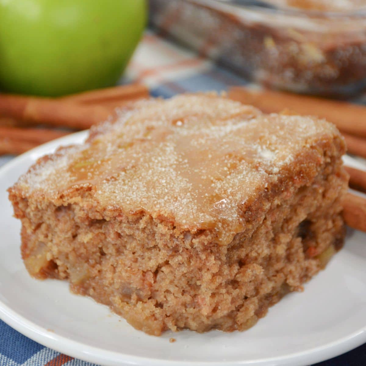 slice of apple cake topped with cinnamon sugar on a plate.