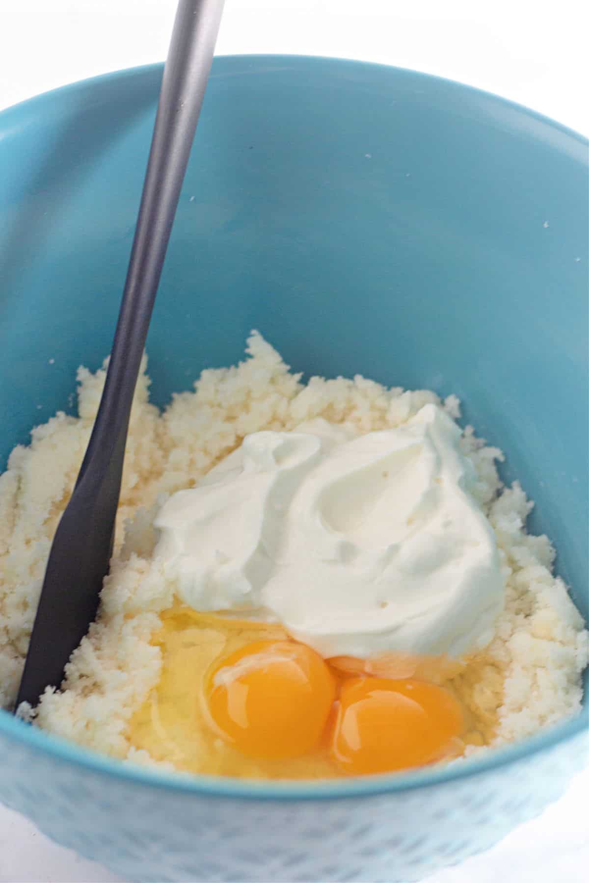 wet ingredient being mixed together in a mixing bowl with a spatula.