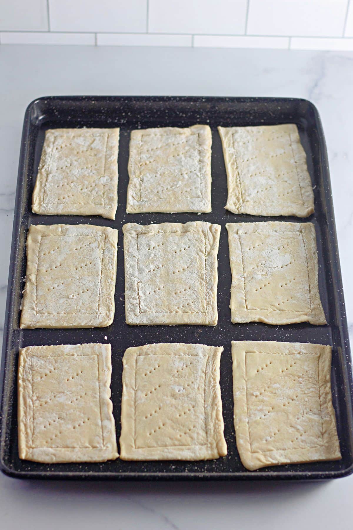 holes being poked in puff pastry dough.