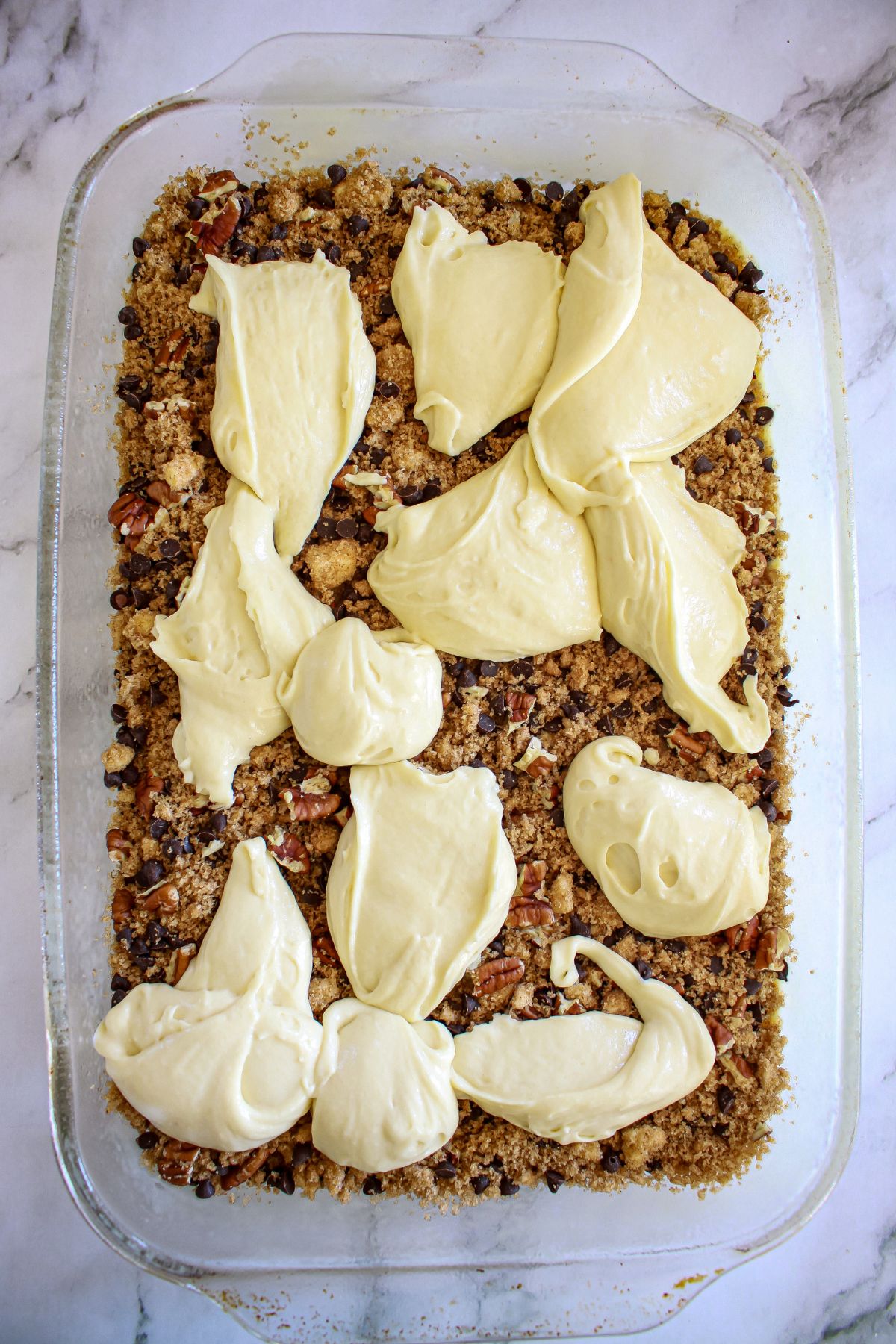 cake batter being added to a glass baking dish.