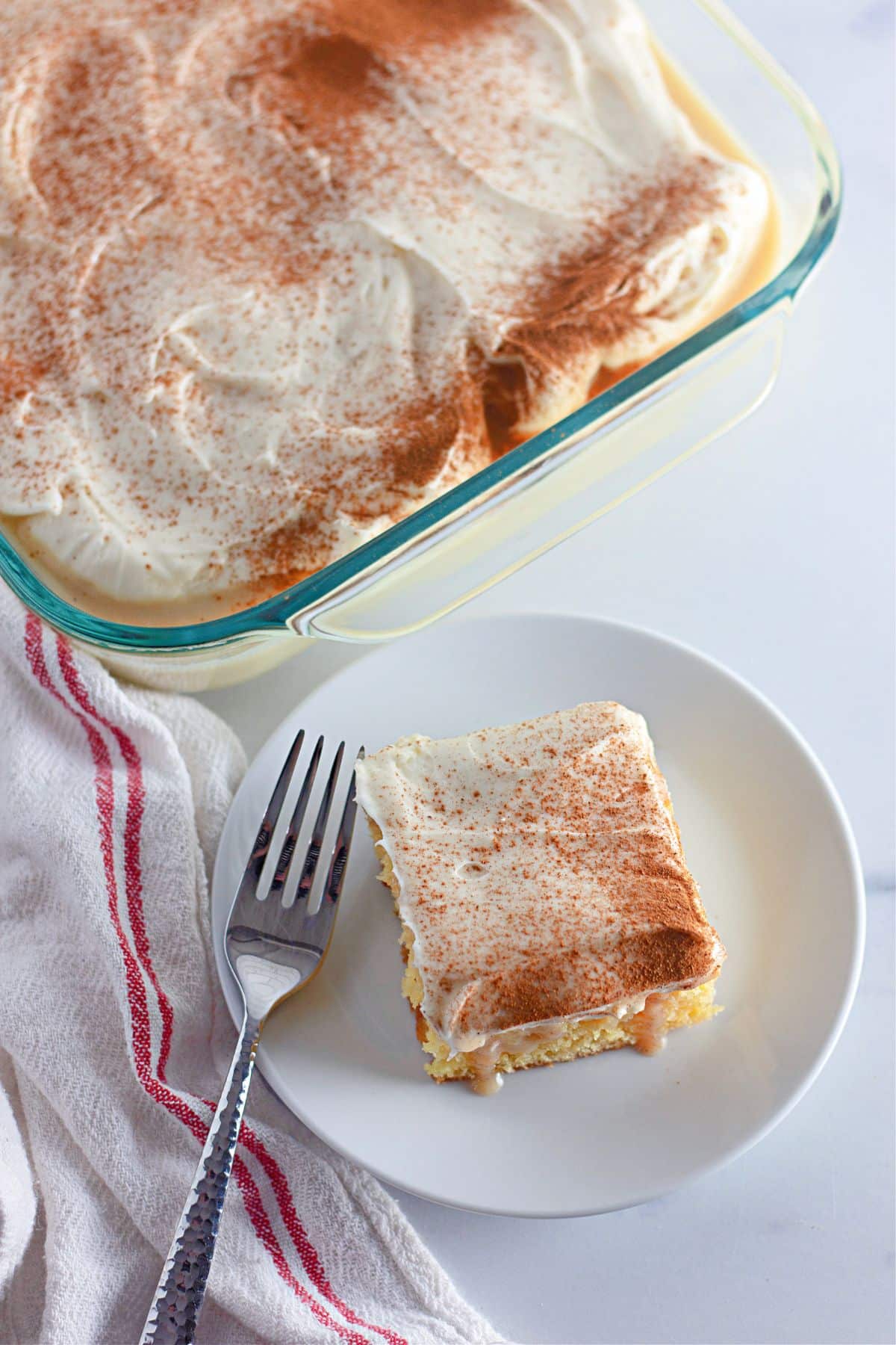 slice of cinnamon roll poke cake on a plate.