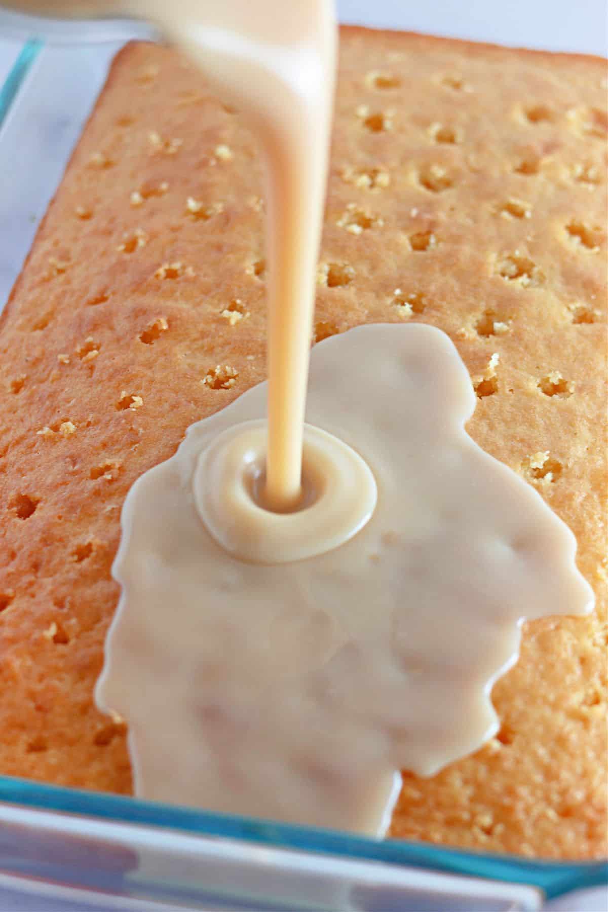 cinnamon roll filling being poured on top of a cake.
