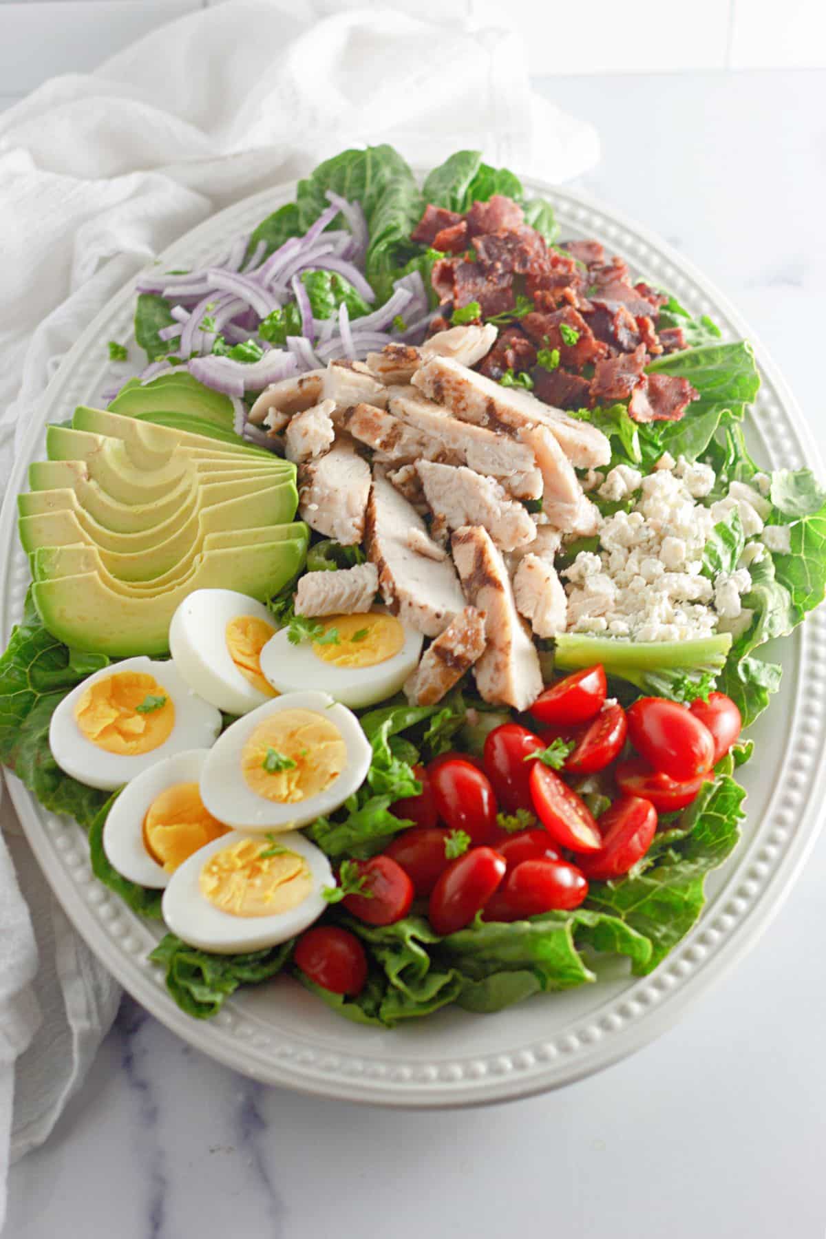 cobb salad layered on a large serving platter.