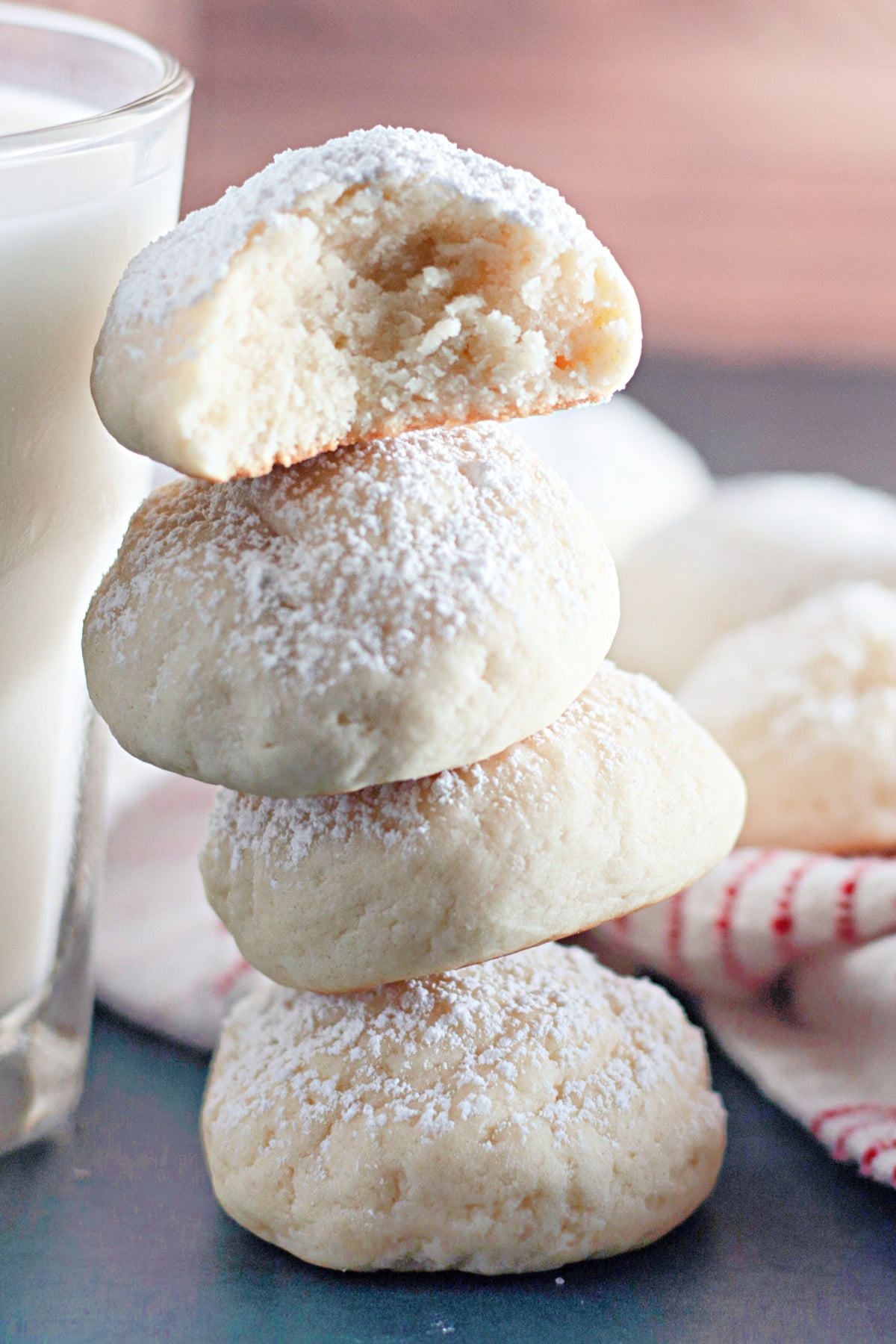 four cream cheese snowball cookies stacked on top of each other.