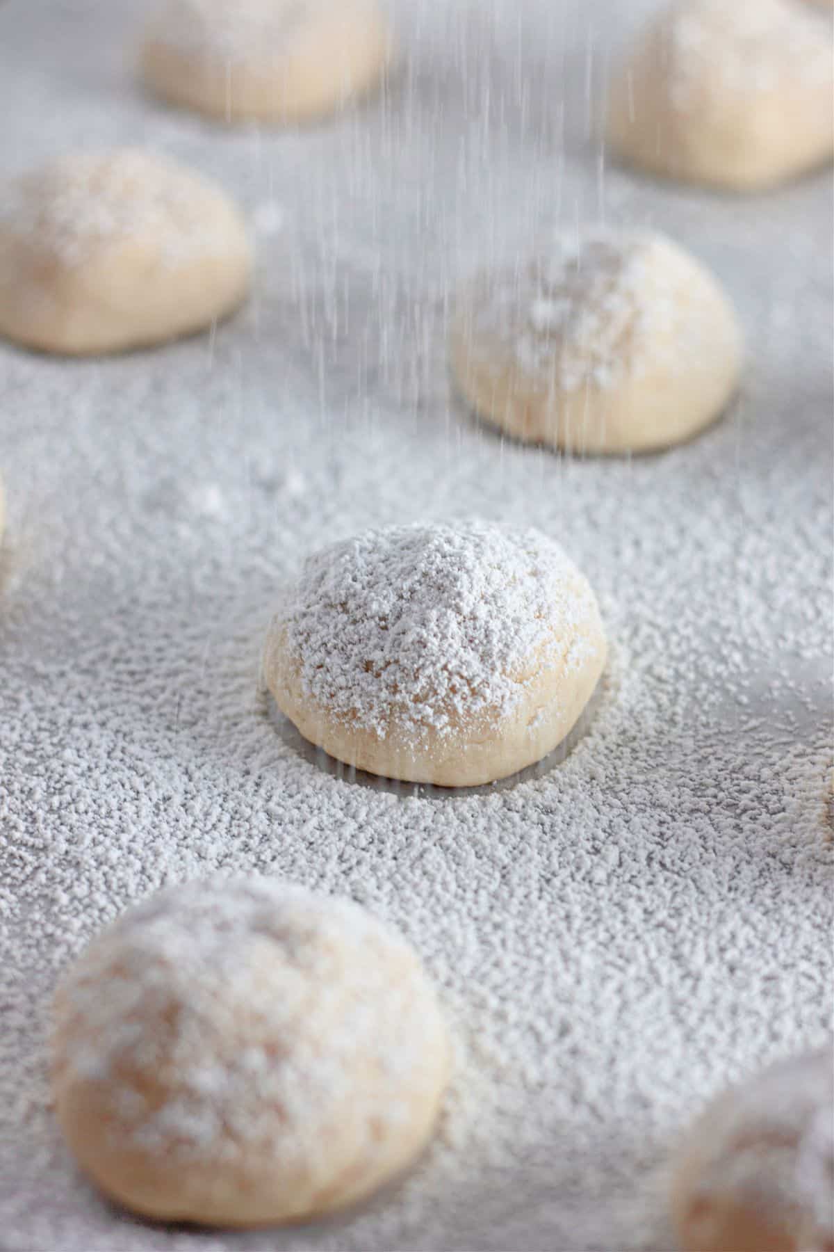 powdered sugar being dusted on top of cookies.