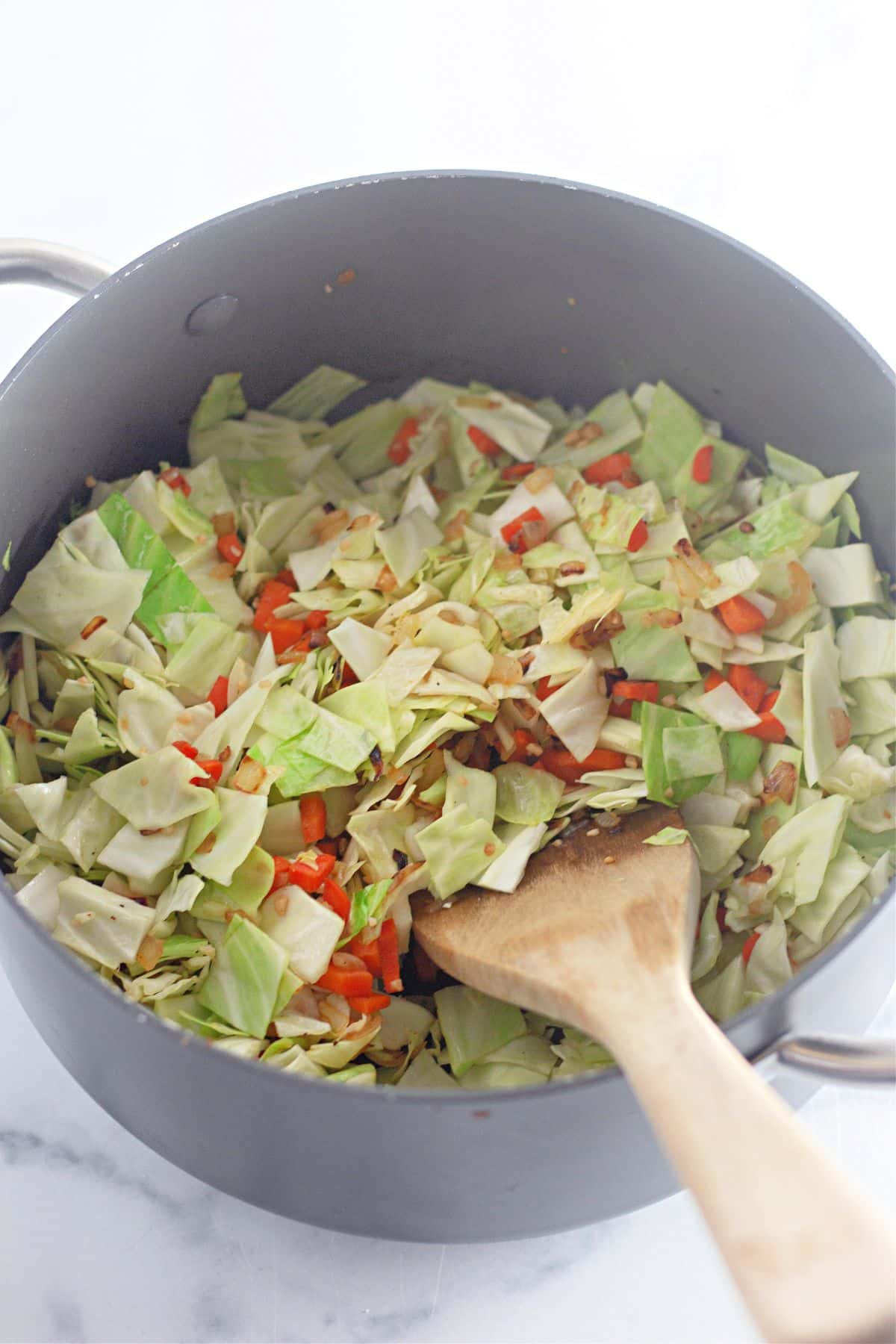 vegetables being sauteed in a large pot.