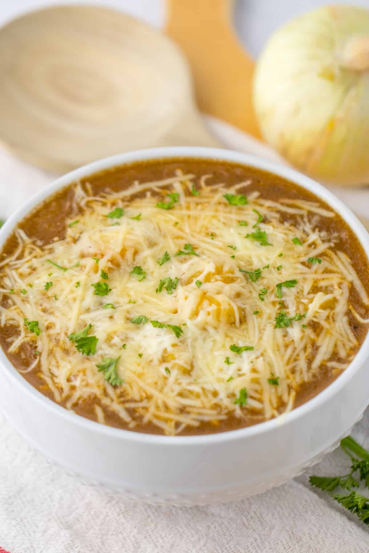 bowl full of french onion gnocchi and topped with cheese and parsley.