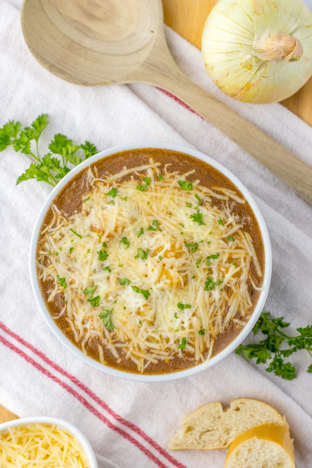 bowl full of french onion gnocchi and topped with cheese and parsley.