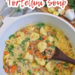 pot full of kale sausage tortellini soup garnished with kale.