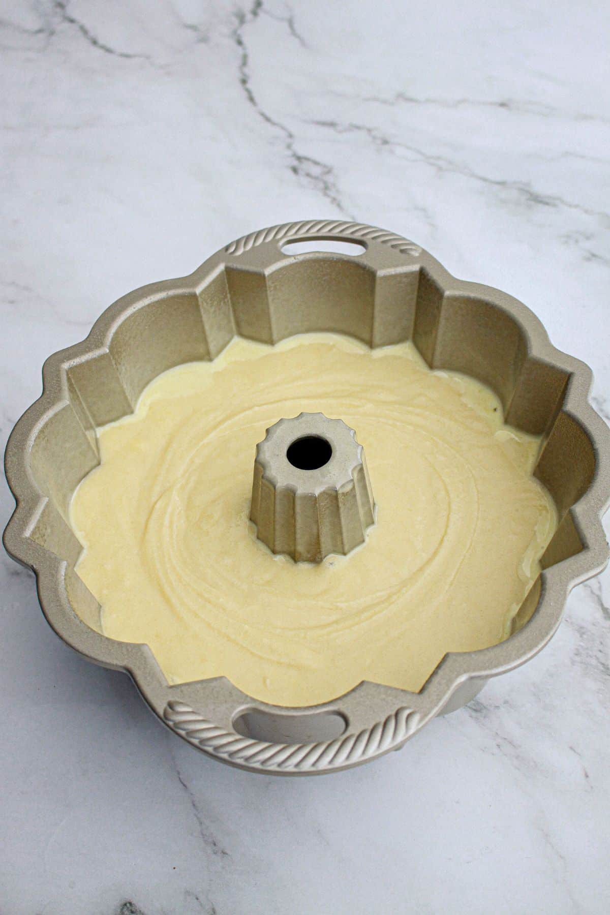 raw cake batter in a bundt pan ready for the oven.