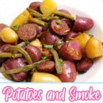 bowl full of potatoes and smoked sausage on a table.