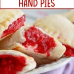 raspberry hand pies cut in half on a plate.