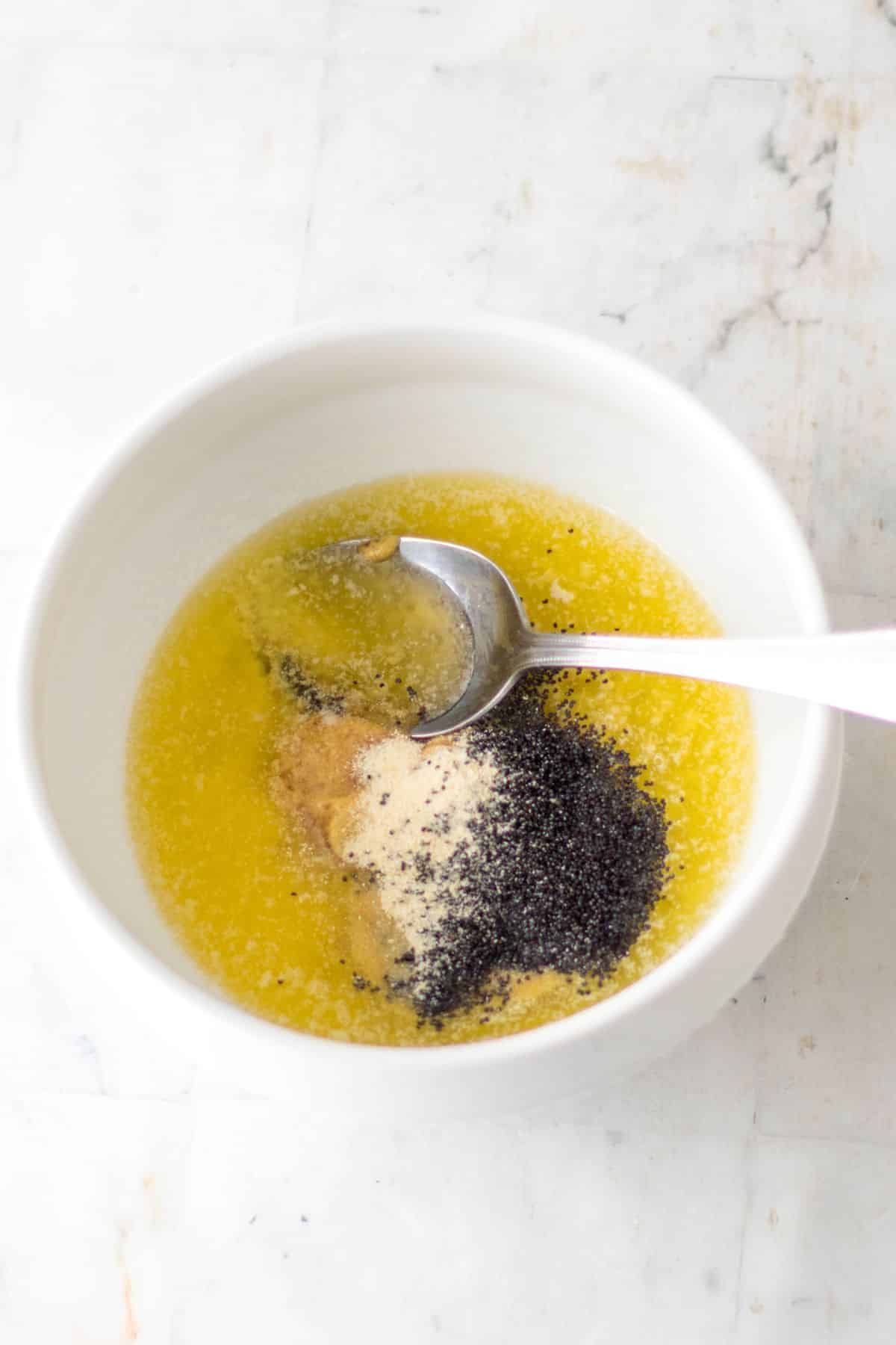 small bowl of melted butter and seasonings being mixed together.