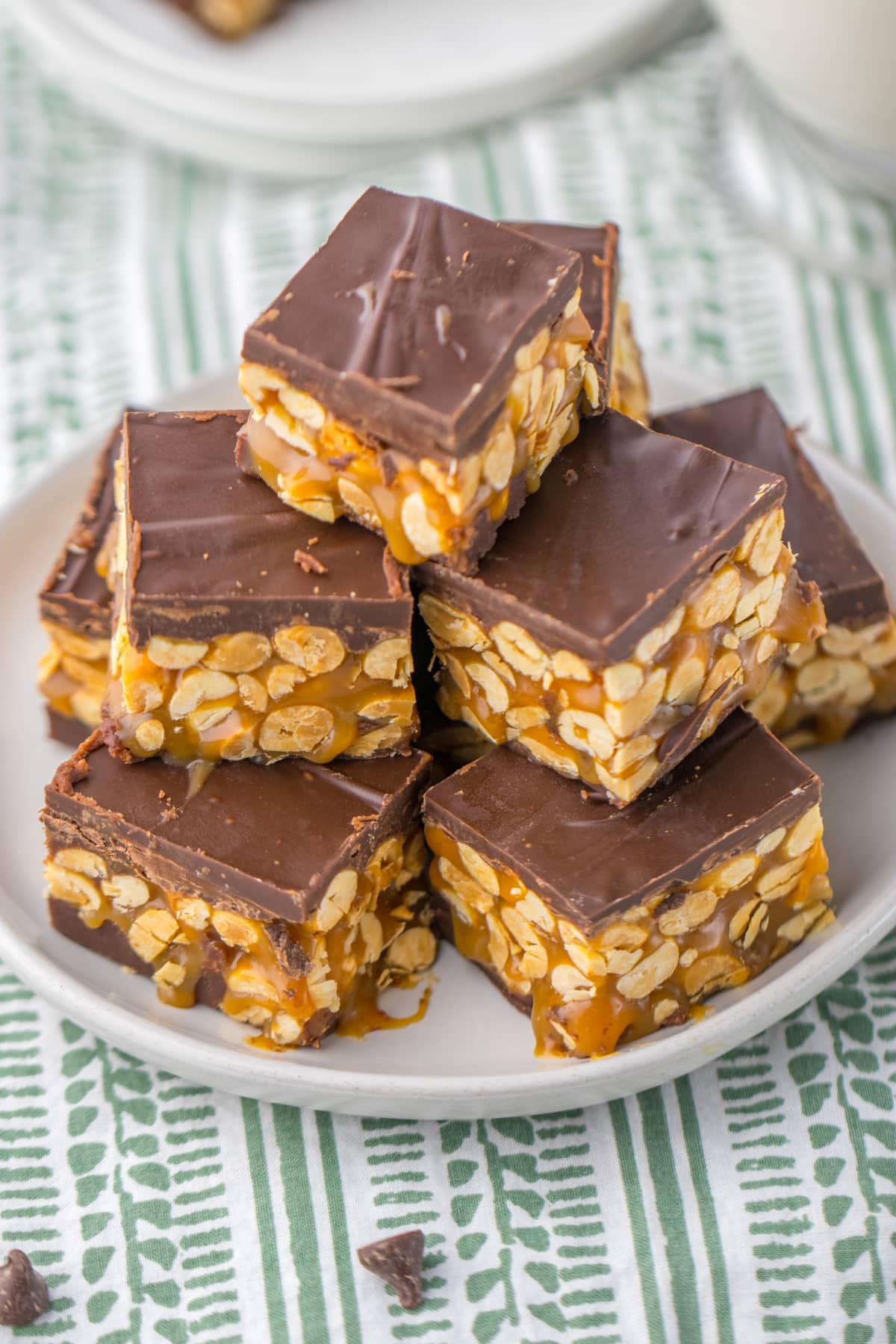 pieces of snickers fudge stacked in a pyramid on a plate.