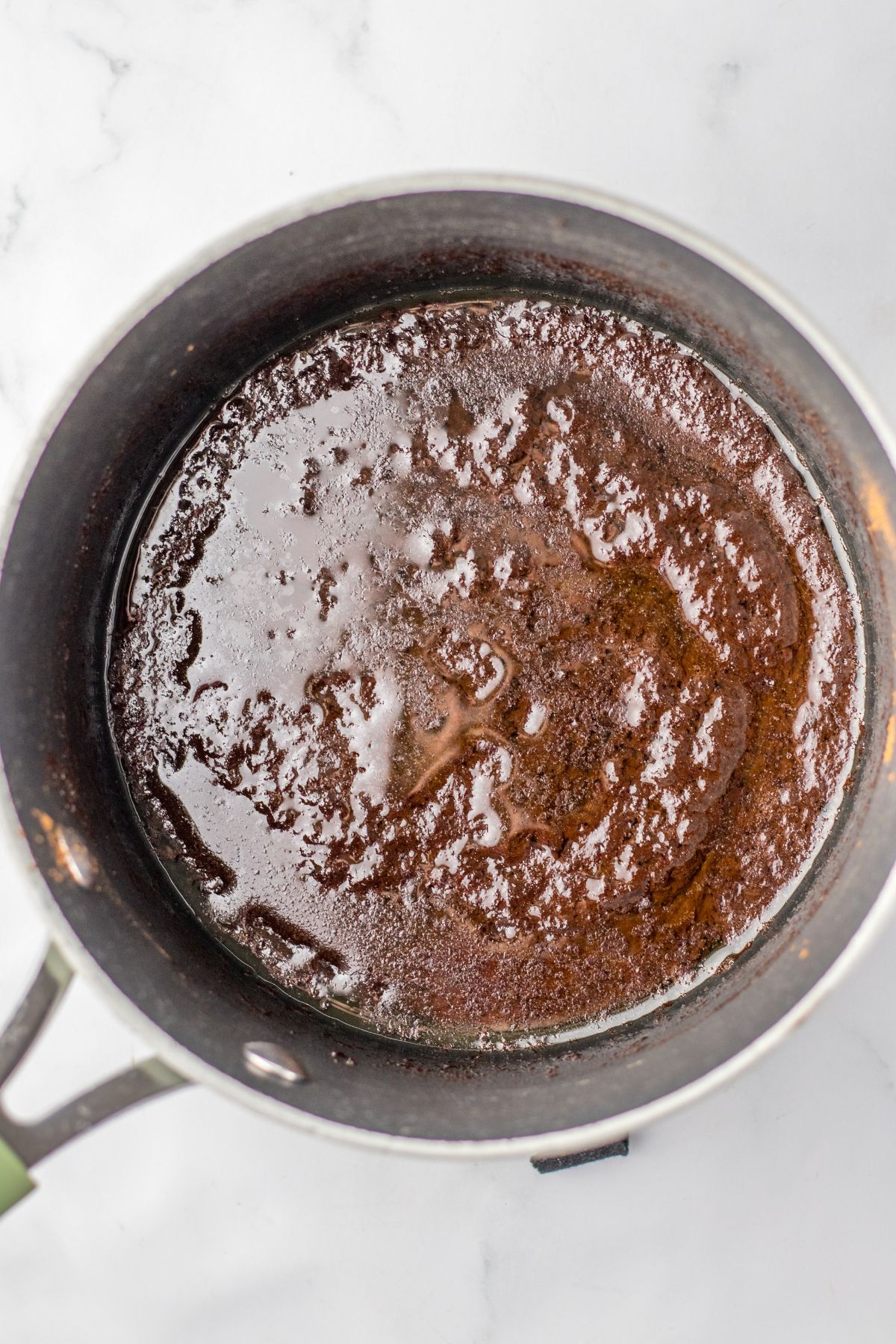 chocolate sauce being cooked in a stainless steel saucepan.