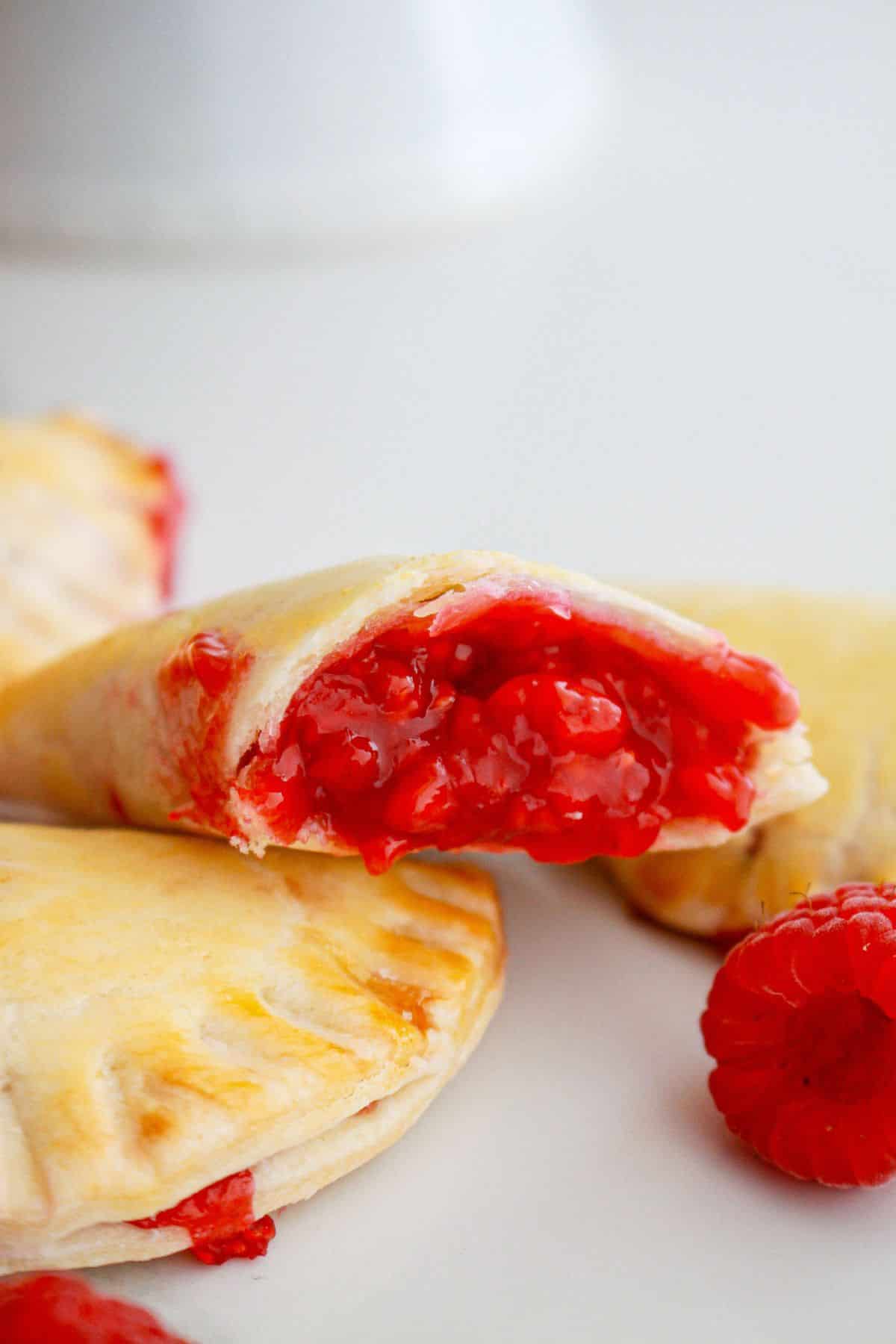 raspberry hand pie broken in half to show the inside.