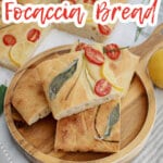 four pieces of tomato focaccia bread stacked on a wooden cutting board.