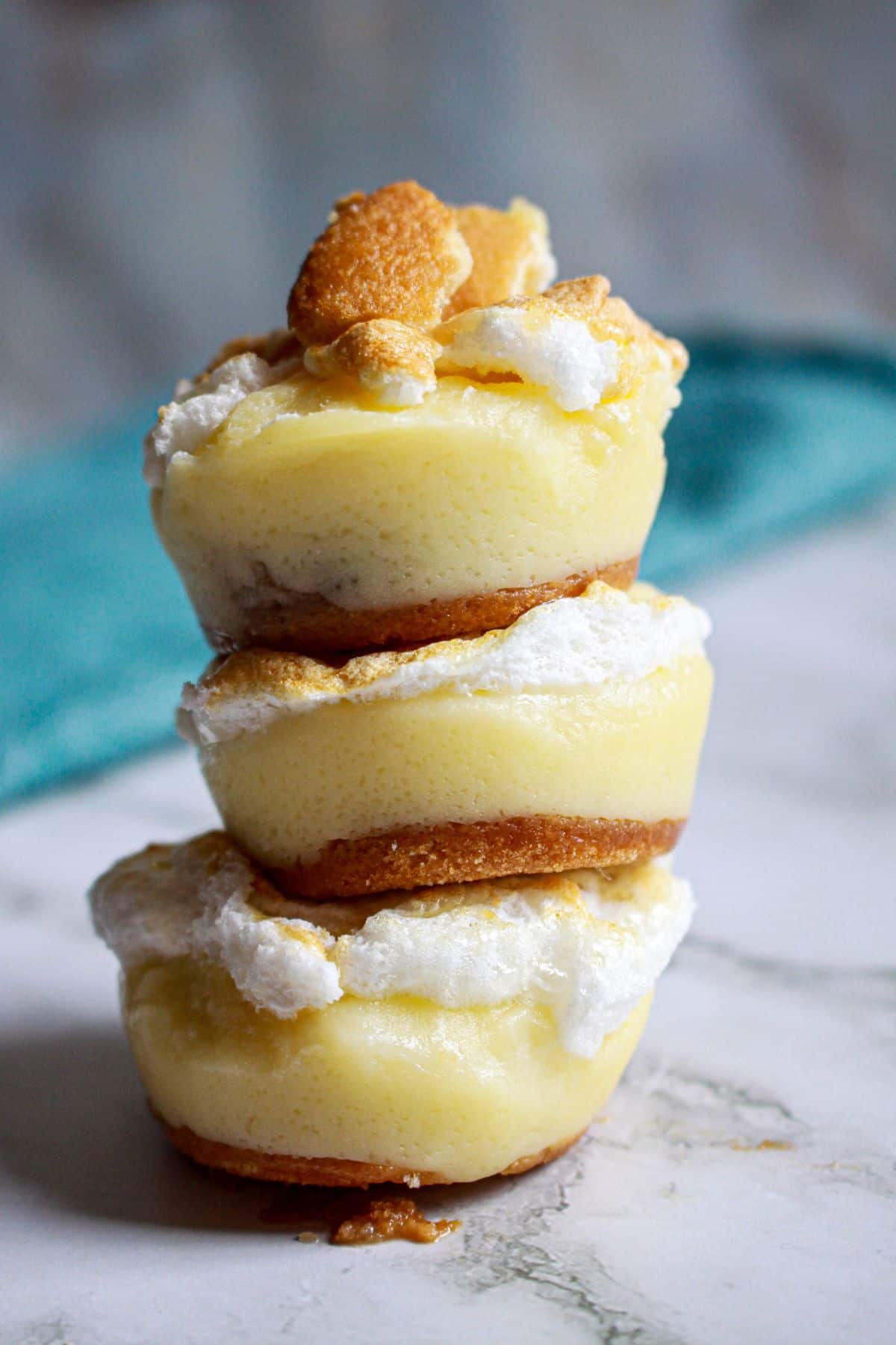 three banana pudding cups stacked on top of each other on a counter.