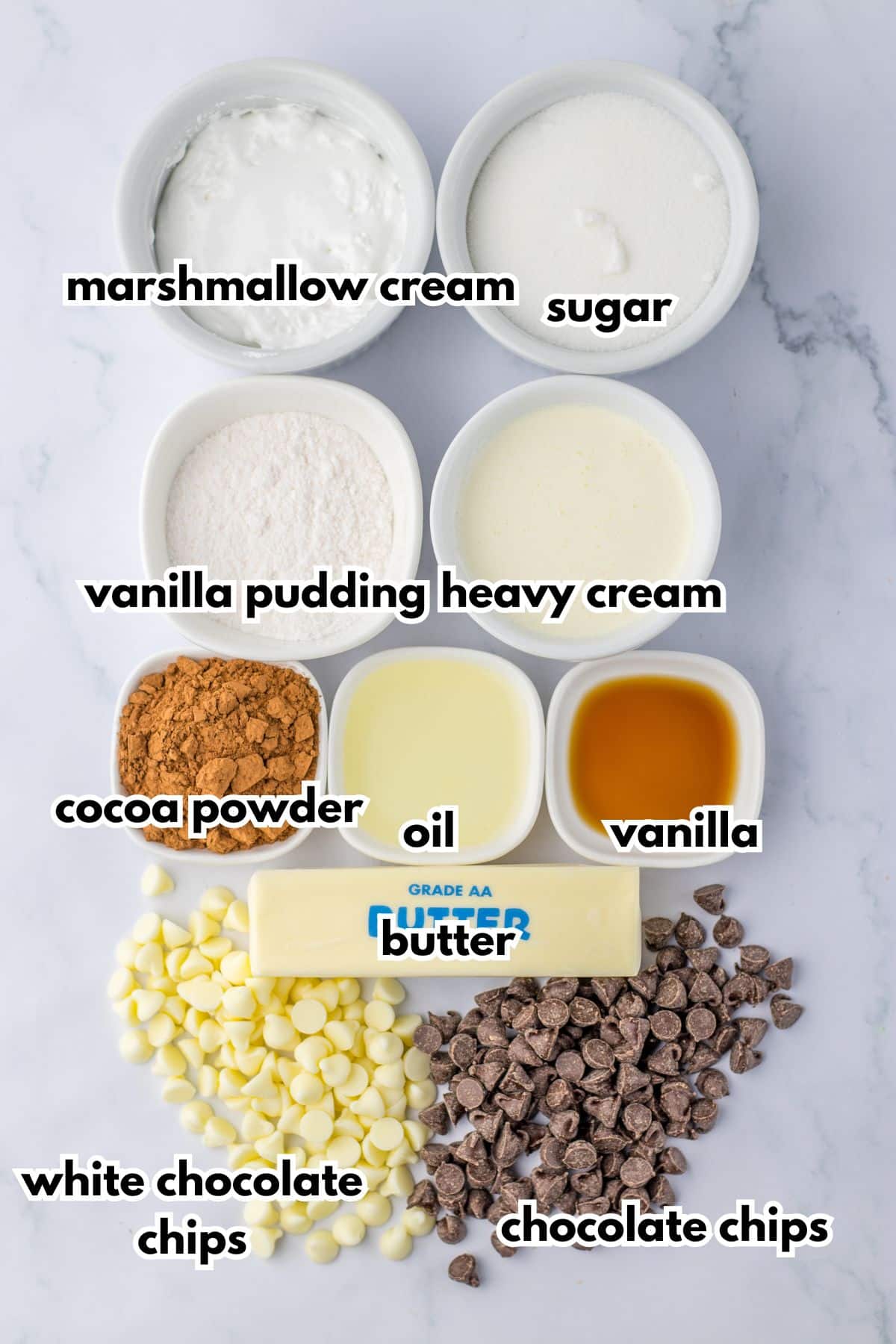 bowls of marshmallow cream, sugar, vanilla pudding, heavy cream, cocoa powder, oil, vanilla, butter, white chocolate chips and chocolate chips.