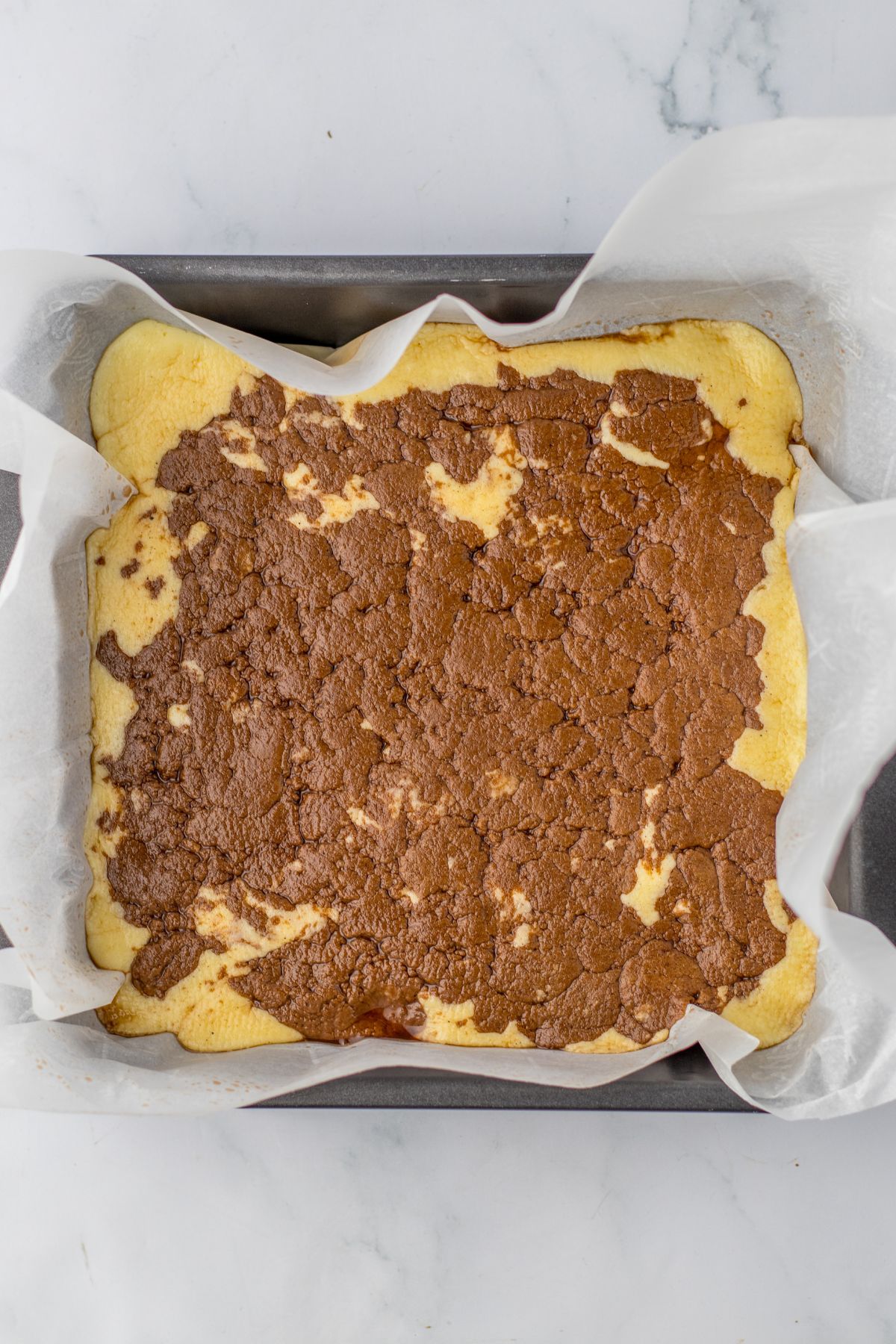 fudge in a square baking dish lined with parchment paper.