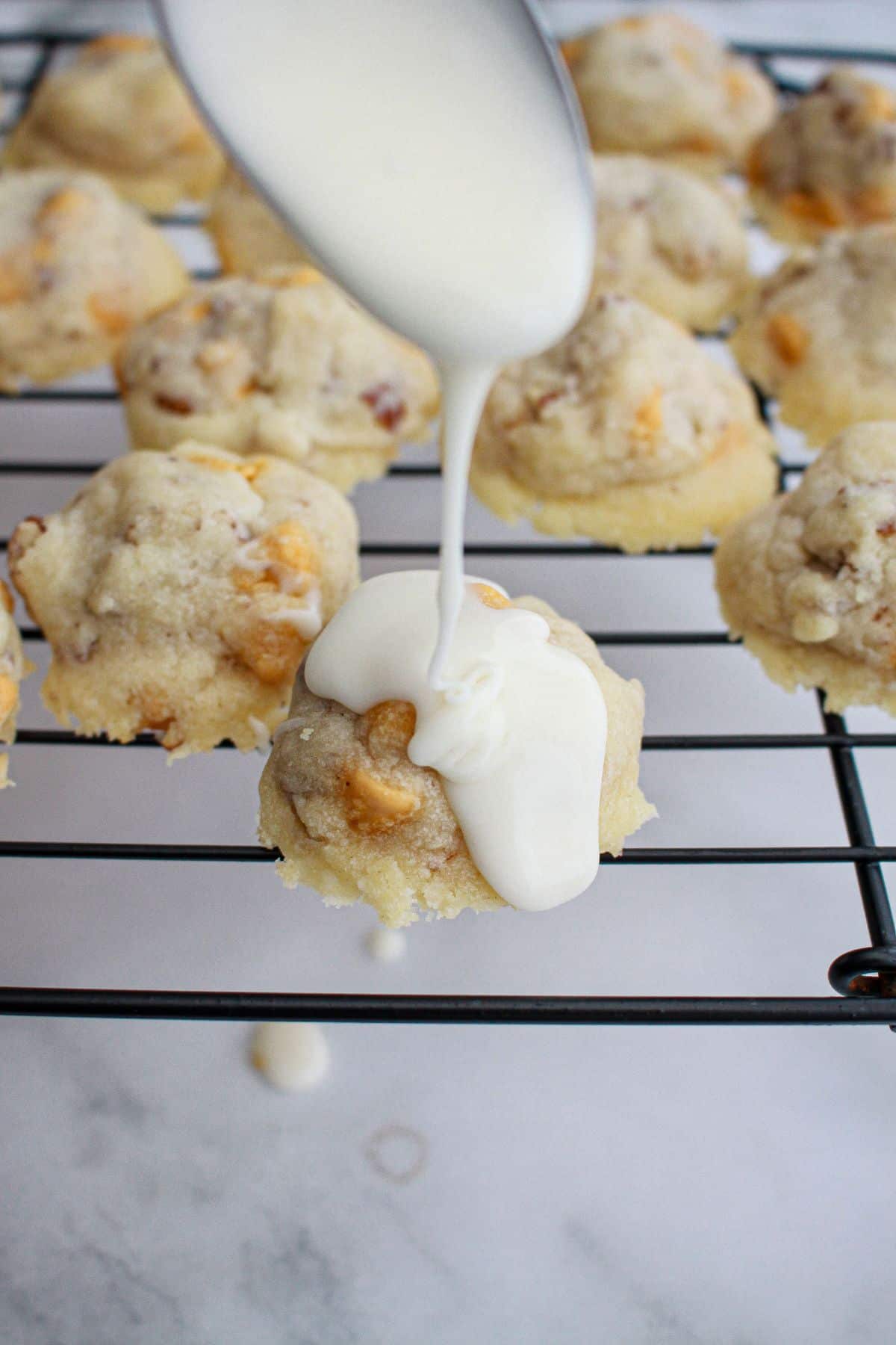 butternut cookies being topped with a glaze.