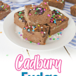 four pieces of cadbury fudge stacked in a pyramid on a plate.