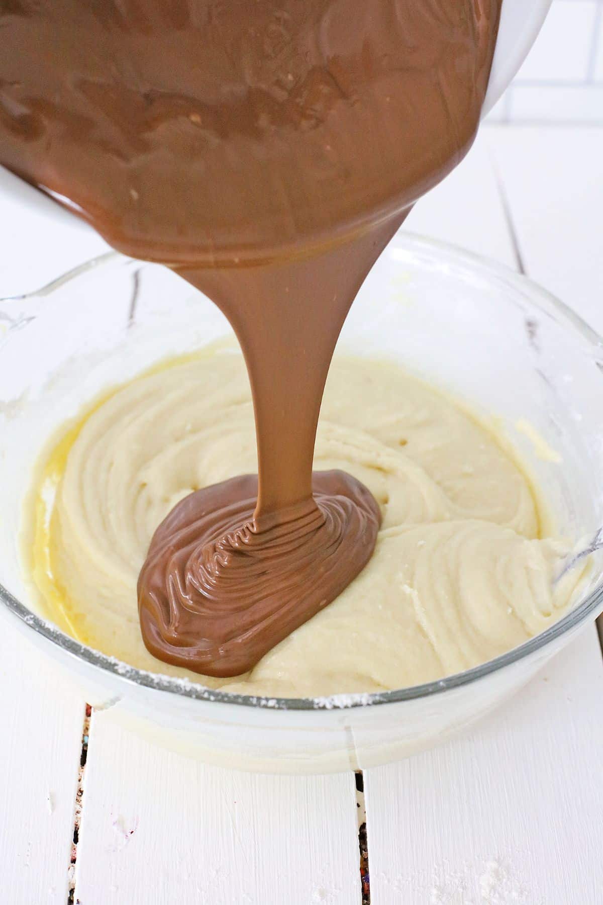 chocolate fudge being added to white chocolate fudge.