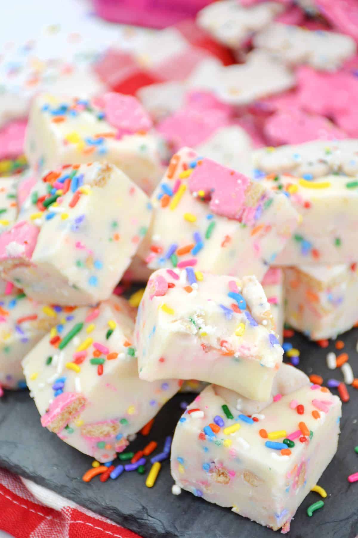 pieces of circus animal cookie fudge stacked on a piece of marble.