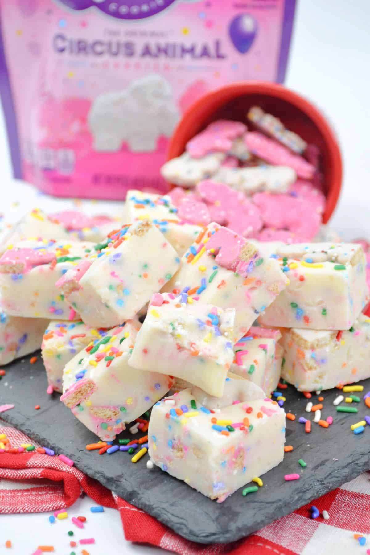 pieces of circus animal cookie fudge stacked on a piece of marble.