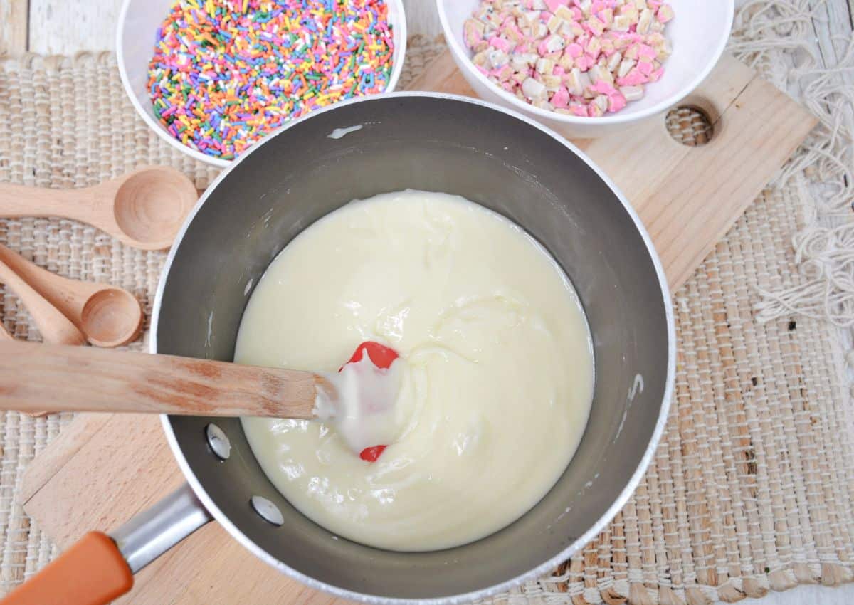 white chocolate being melted in a saucepan.