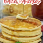 four pancakes on a plate topped with a pat of butter, and syrup.