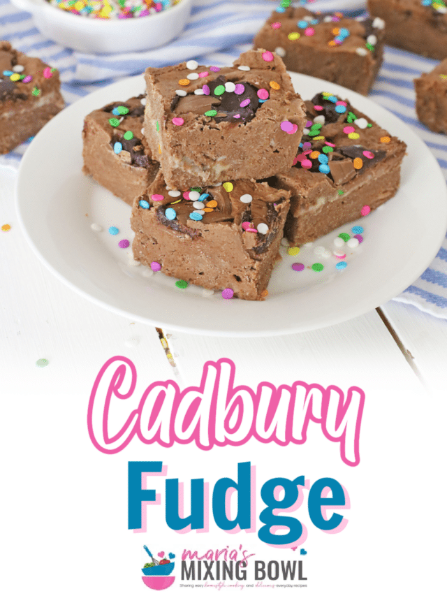 four pieces of cadbury fudge stacked in a pyramid on a plate.